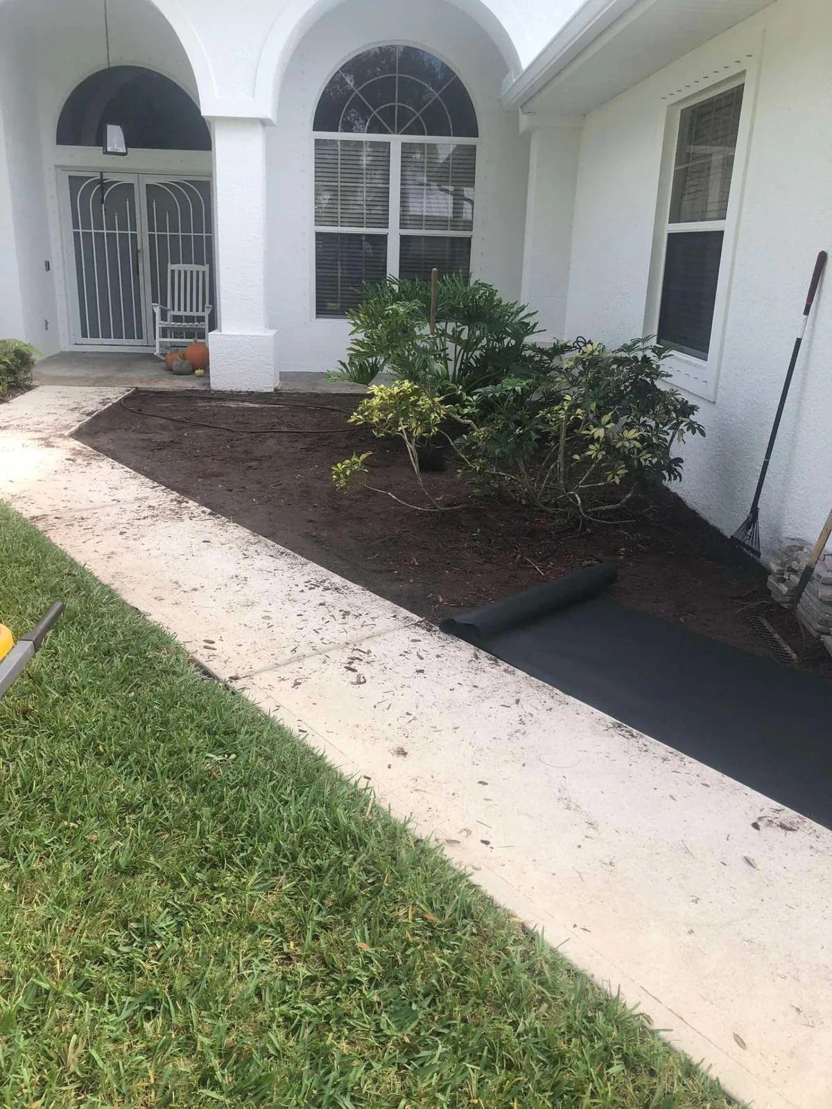 Front entry garden bed prepared with soil and edging for new plantings